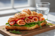 A croissant filled with smoked salmon, cherry tomatoes, and lettuce